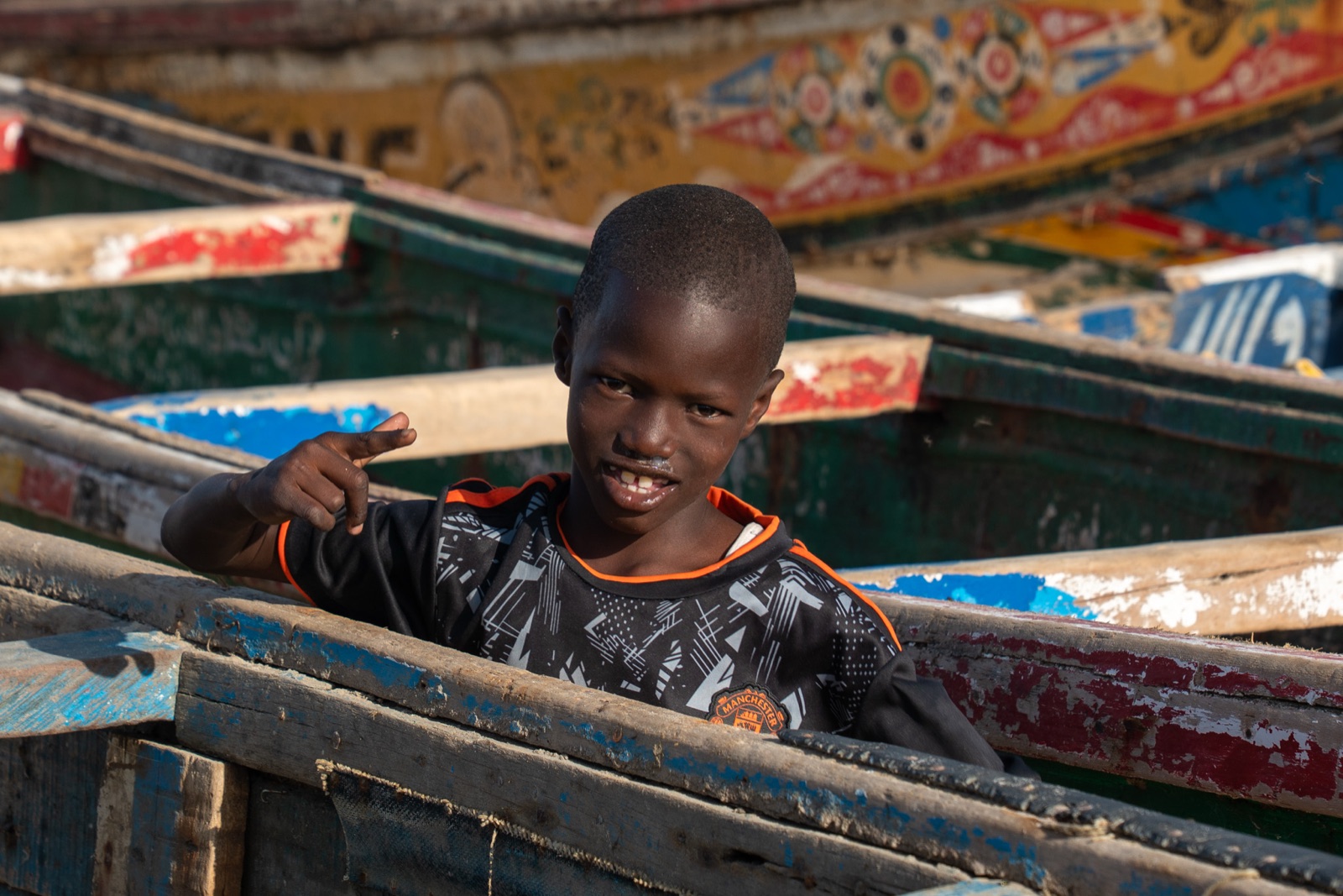 A boy between fishing pirogues in Saint-Louis.